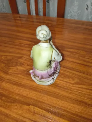 Figura de porcelana anciana con peces