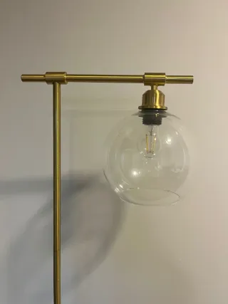 Lámpara de pie dorada con globo de cristal