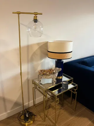 Lámpara de pie dorada con globo de cristal