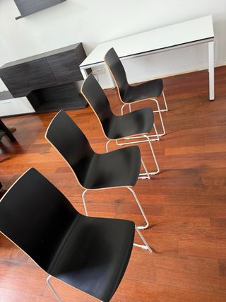 Mesa blanca con 4 sillas negras