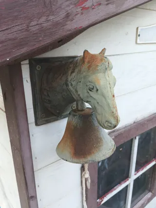 Campana de hierro con cabeza de caballo