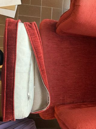 Sillón de tela rojiza  El cojin es de plumas
