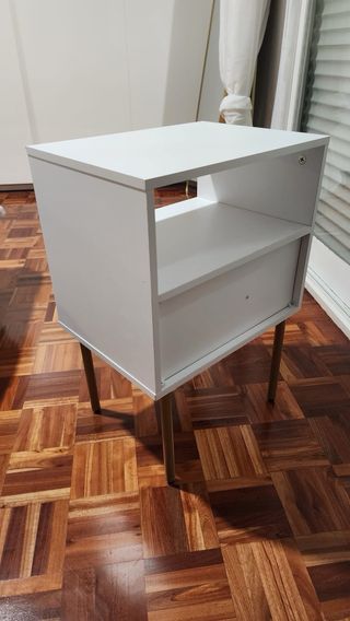 Mesita de noche blanca con detalles dorados