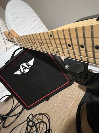 Guitarra eléctrica negra con amplificador