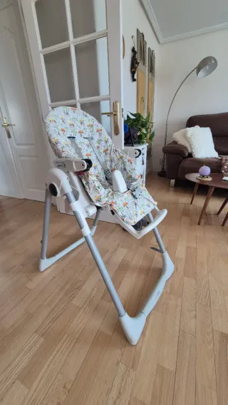 Trona bebé con funda estampada, es acolchada.