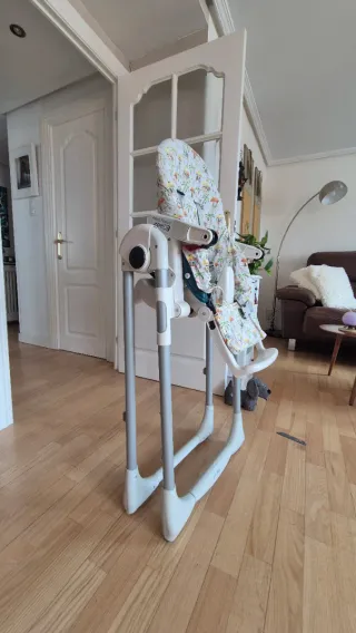 Trona bebé con funda estampada, es acolchada.