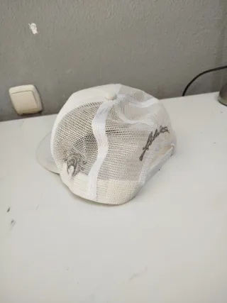 Gorra trucker blanca con rejilla ajustable.