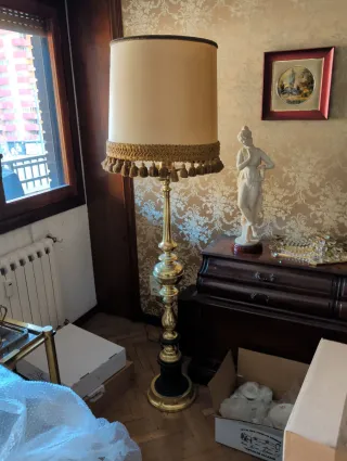 Lámpara de pie dorada con flecos