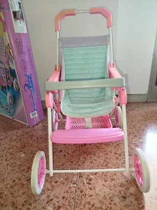 Silla de paseo para muñecas de color rosa