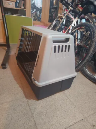 Jaula transporte mascotas beige y negro.