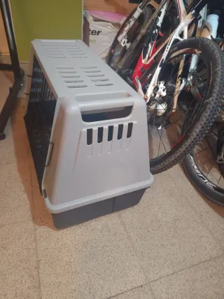 Jaula transporte mascotas beige y negro.