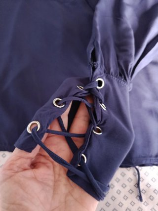 Camicia blu con laccetti ai polsi e collo