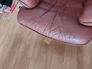 Silla giratoria de piel marrón y patas de madera