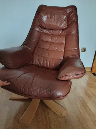 Silla giratoria de piel marrón y patas de madera