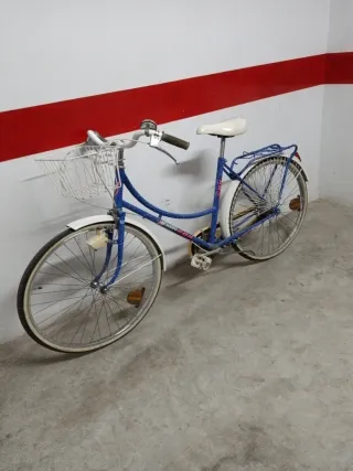 Bicicleta azul con cesta y portabultos