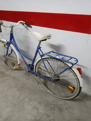 Bicicleta azul con cesta y portabultos