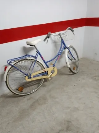 Bicicleta azul con cesta y portabultos