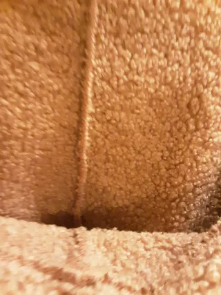 Chaqueta rosa con capucha y cremallera. Es amplia