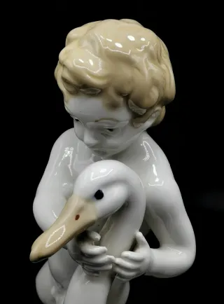 Bonita figura antigua de porcelana niño con cisne