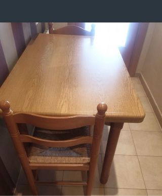 Mesa de cocina de madera con un cajon sin sillas.