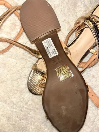 Sandalias doradas con tiras estilo serpiente.