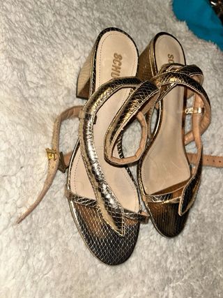 Sandalias doradas con tiras estilo serpiente.