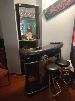 Barra de bar negra con estantería y taburetes