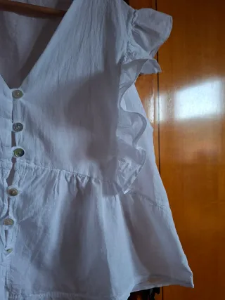 Blusa blanca sin mangas con volante