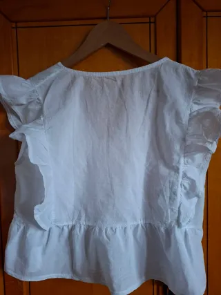 Blusa blanca sin mangas con volante