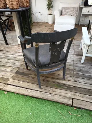 Sillón negro con brazos y detalles dorados