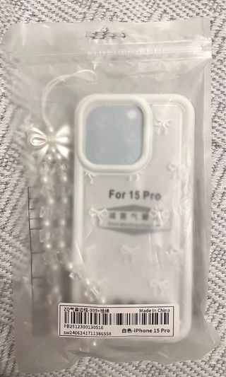 Funda iPhone 15 Pro con colgante de perlas.