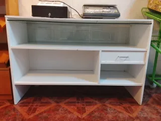 Mostrador blanco con estantes y cajón