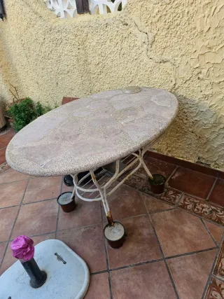 Mesa de piedra ovalada con base de metal