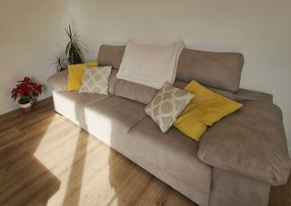 Sofá  gris con cojines y manta de regalo