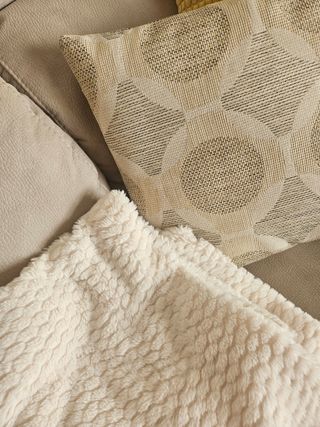 Sofá  gris con cojines y manta de regalo