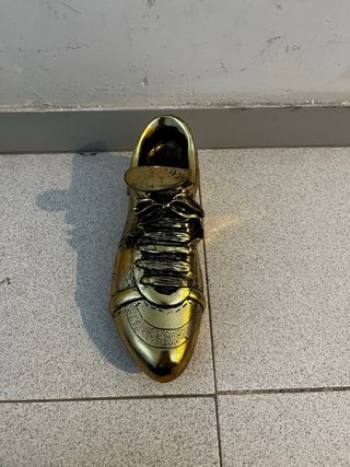 Bota de fútbol de metal dorado