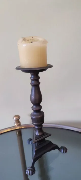 Portavelas antiguo de metal con vela