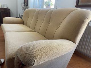 Sofá de tela beige con detalles de madera