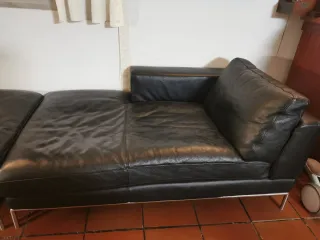 Sofá de piel negra con estructura metálica