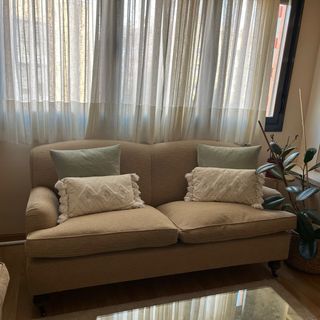 Sofás vintage beige de tela y madera.