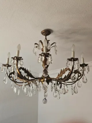 Lámpara de araña dorada con cristales.