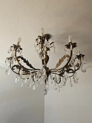 Lámpara de araña dorada con cristales.