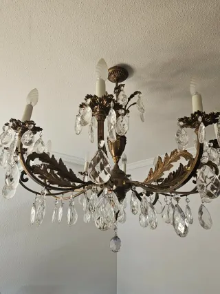 Lámpara de araña dorada con cristales.