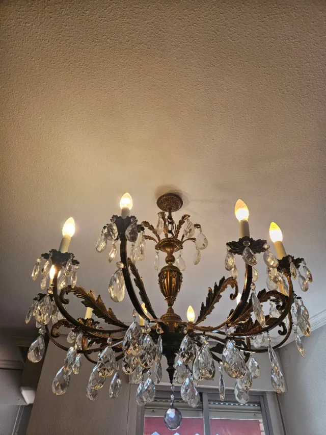 Lámpara de araña dorada con cristales.