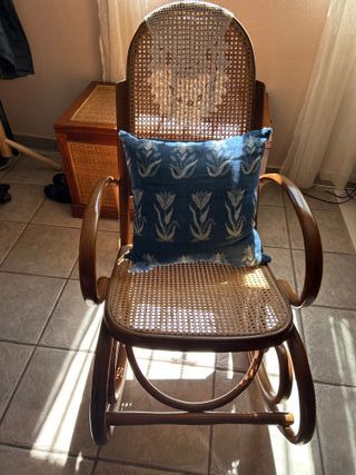Vecchia sedia a dondolo in legno e rattan