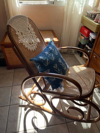 Vecchia sedia a dondolo in legno e rattan