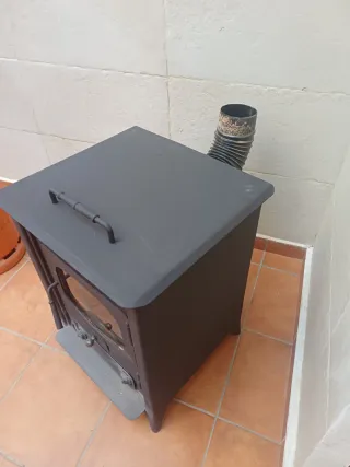 Estufa de leña negra, con salida de humo de 12cm.