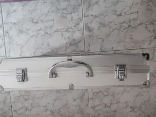 Maletín de aluminio plateado. No tiene marca.