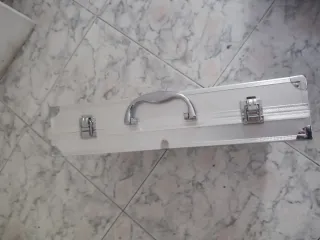 Maletín de aluminio plateado. No tiene marca.