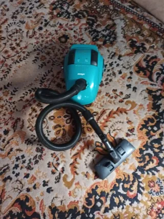 Aspiradora azul con manguera y cepillo